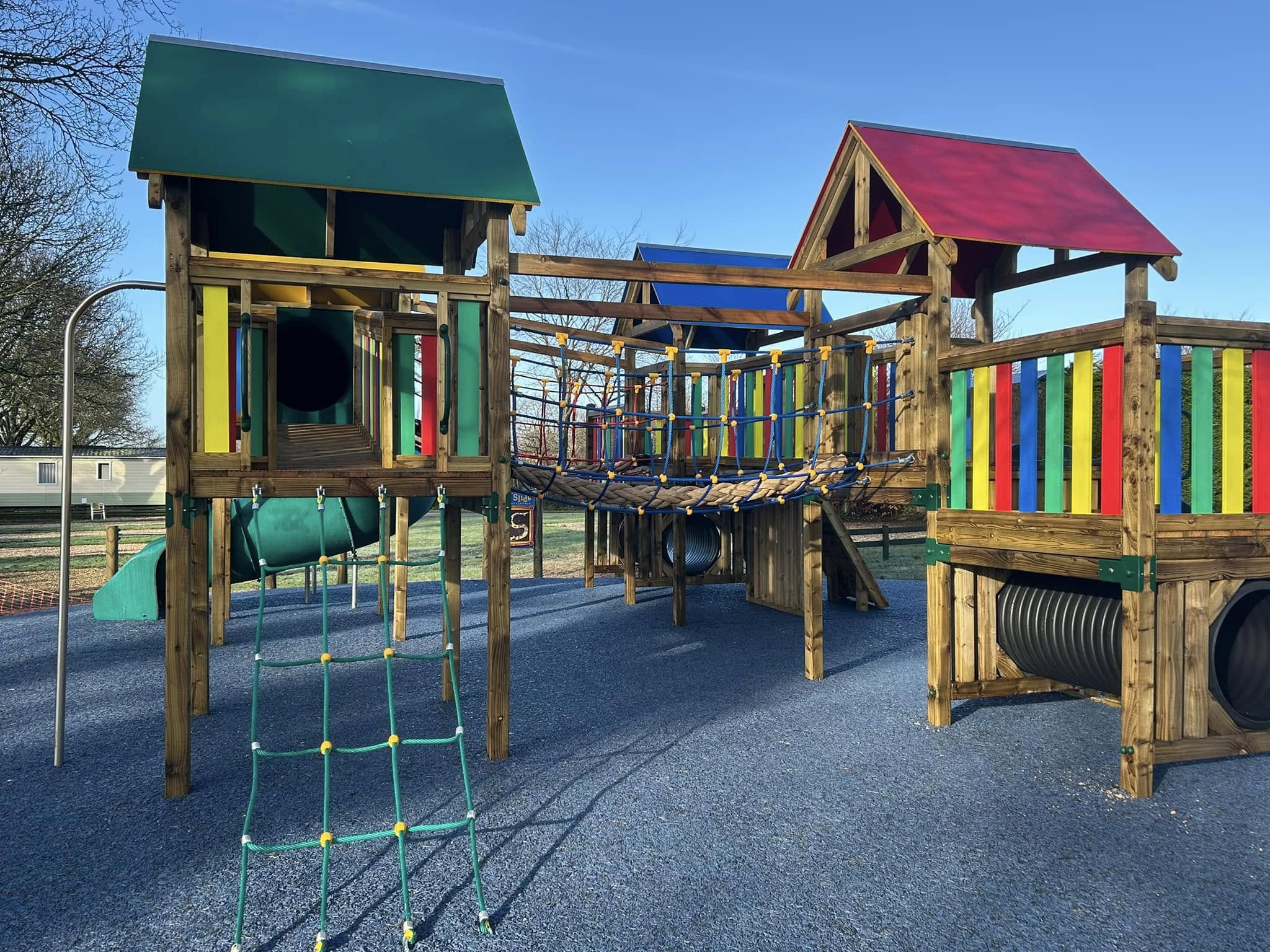 The wooden play equipment at Oakdown with its coloured roofs and climbing nets, empty in the early light