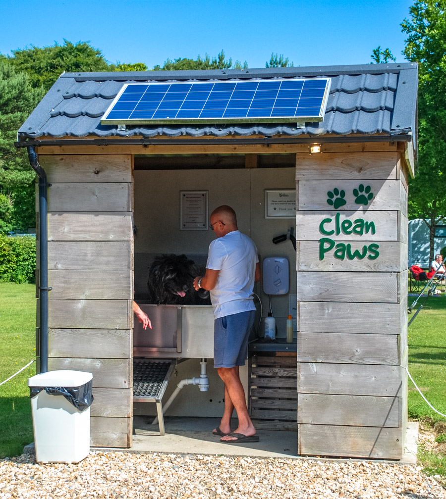 The timber Clean Paws building with a solar panel on the roof and a dog being washed in the sink inside